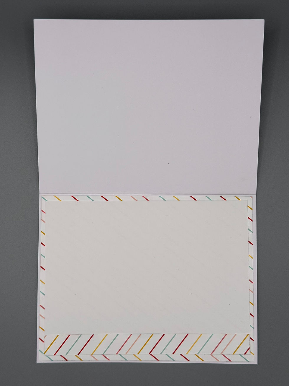Thumbnail: “Inside of greeting card with white writing area bordered by colorful diagonal stripes.”