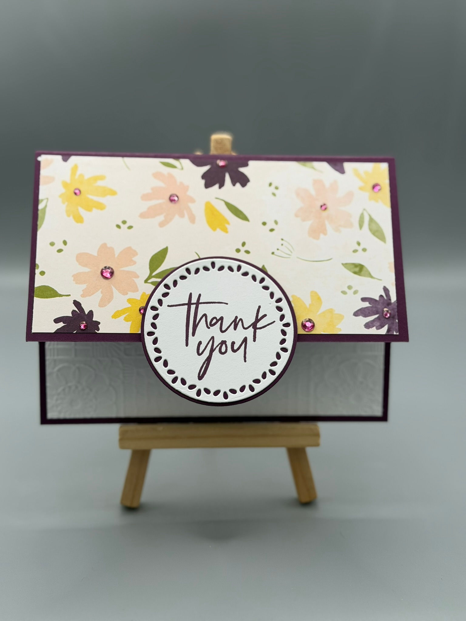Handmade floral thank‑you card with pastel flowers, purple border, gem accents, and circular “Thank You” message; inside read