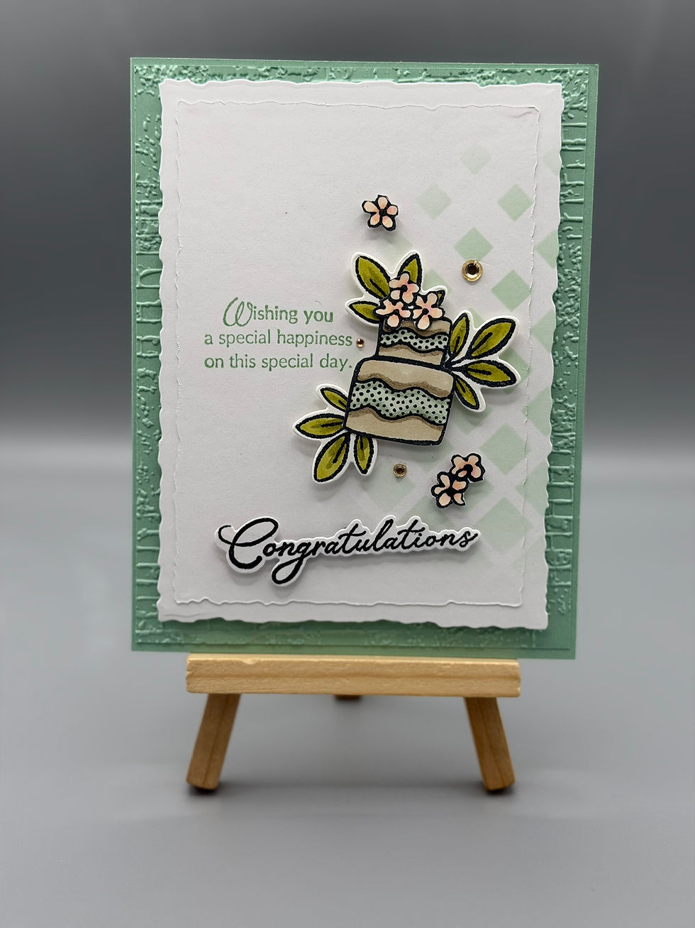 Layered mint-green and white greeting card with raised floral cake illustration and the message “Wishing you a special happin