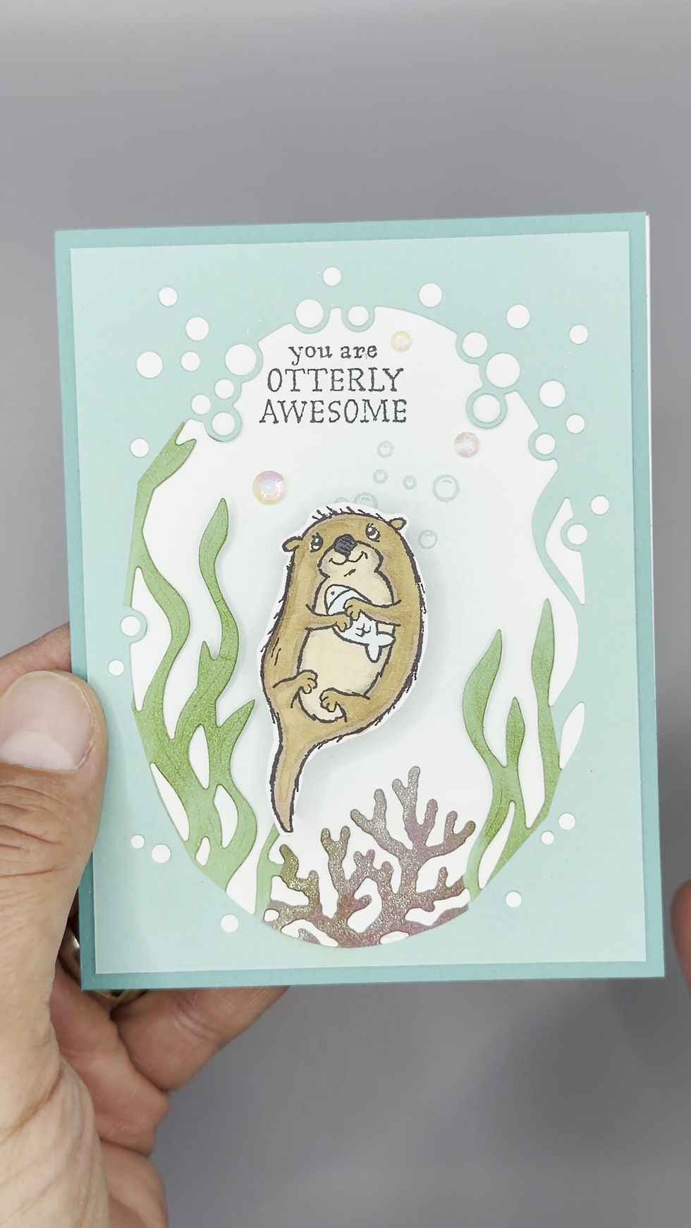 Thumbnail: Handmade greeting card featuring a cute otter holding a seashell with “You are Otterly Awesome” message and underwater design