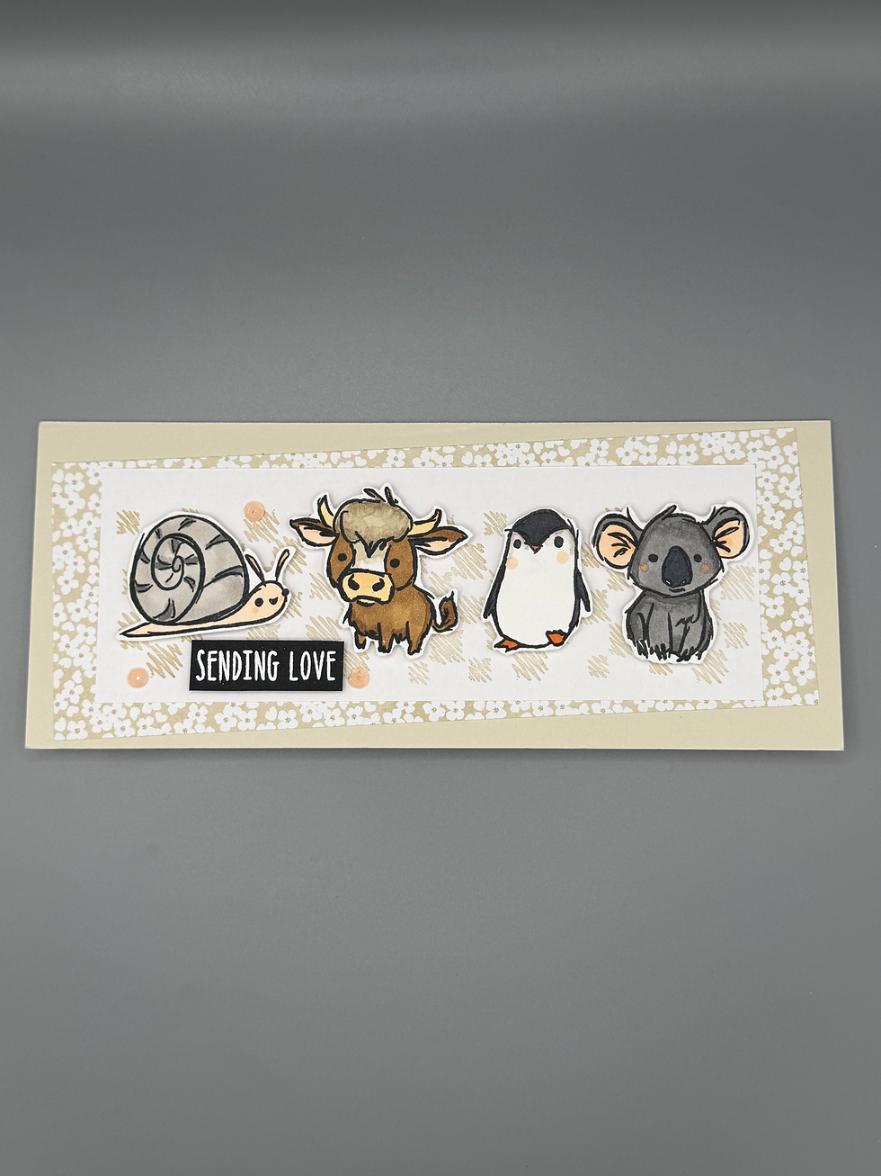 Thumbnail: Handmade slimline greeting card featuring snail, bison, penguin, and koala with “Sending Love” message on floral background.