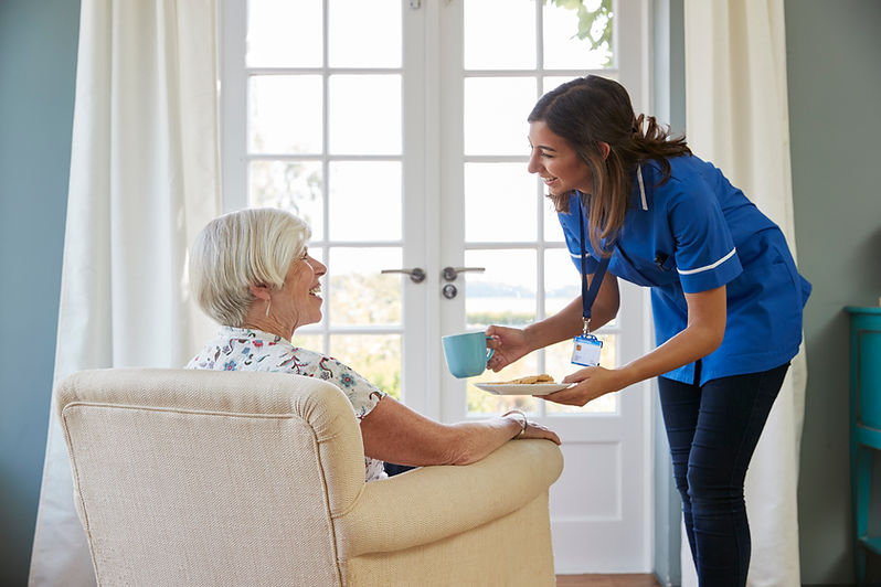 nurse-serving-tea-biscuits-senior-woman-home.jpg