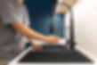 person-reaching-matte-black-kitchen-faucet-before-turning-water.jpg
