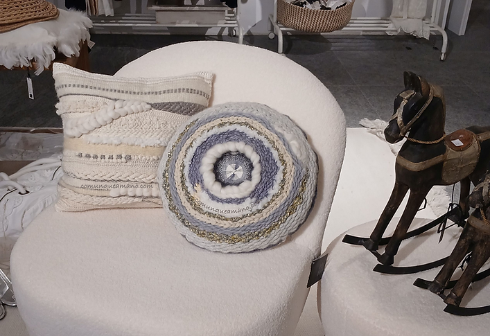 Cuscini panna e grigio su poltrona bianca in negozio