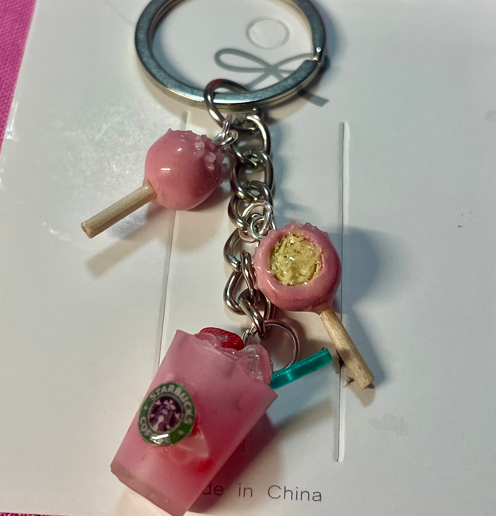 keychain of starbucks pink drink with strawberries and ice and pink cake pops, one with a bite mark