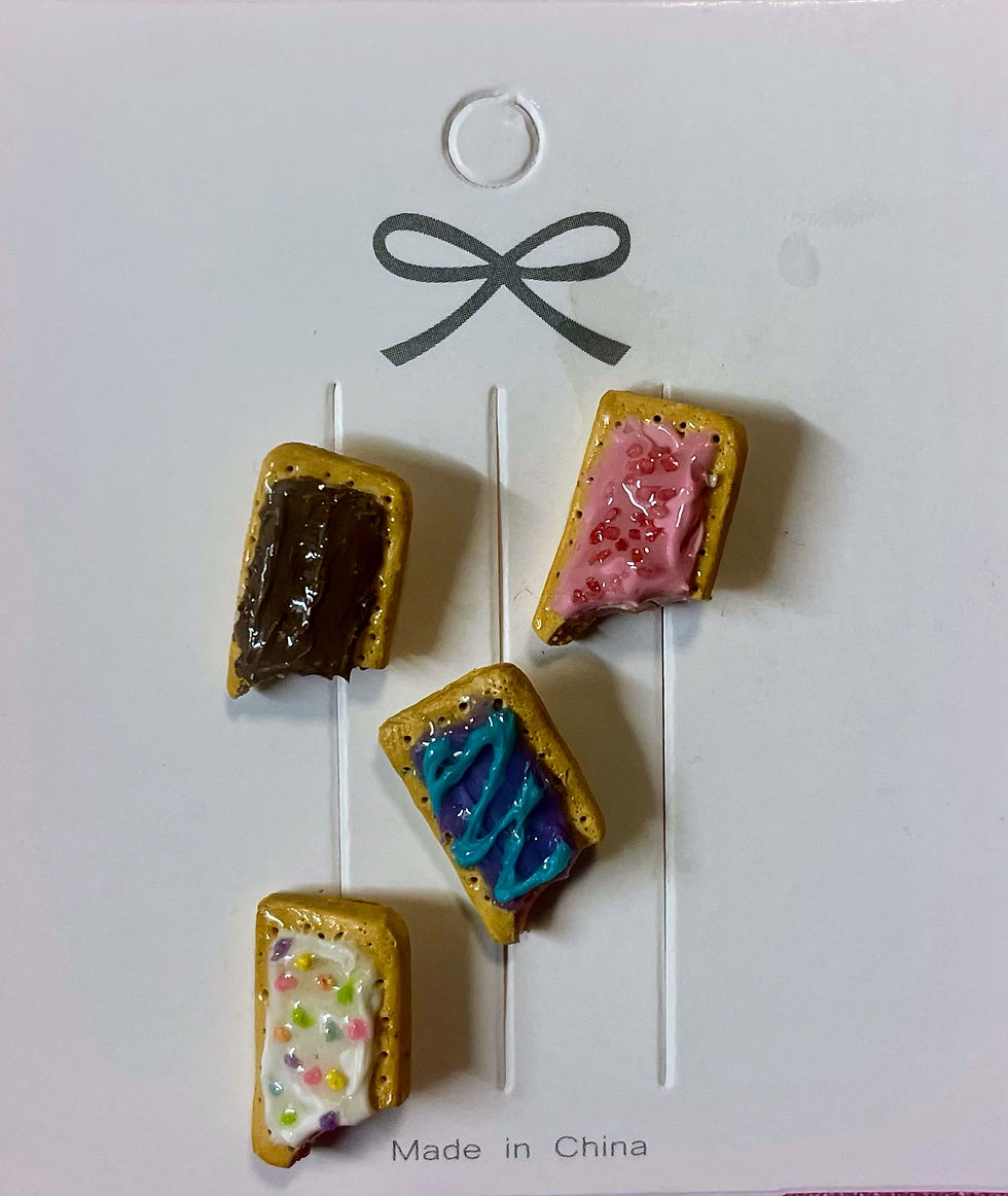 lapel pins of four pop tarts including blue wild berry, cherry, strawberry and smores poptart, all pop tarts have a bite mark