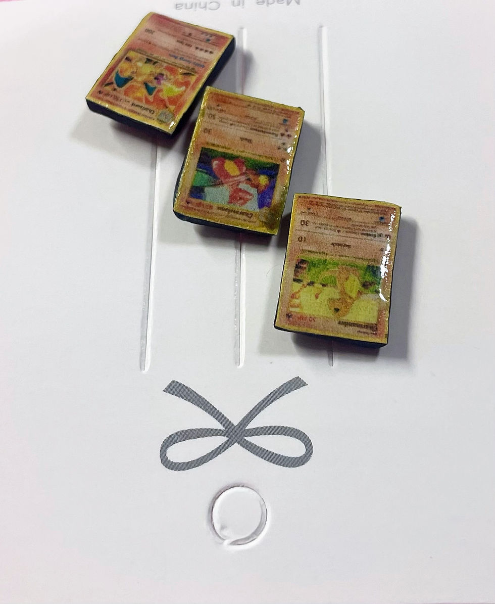 Thumbnail: lapel pins of three pokemon cards including charmander and charmeleon and charizard