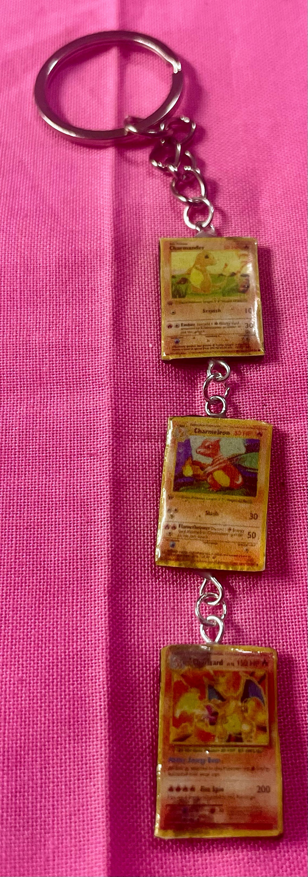 keychain of three pokemon cards including charmander and charmeleon and charizard