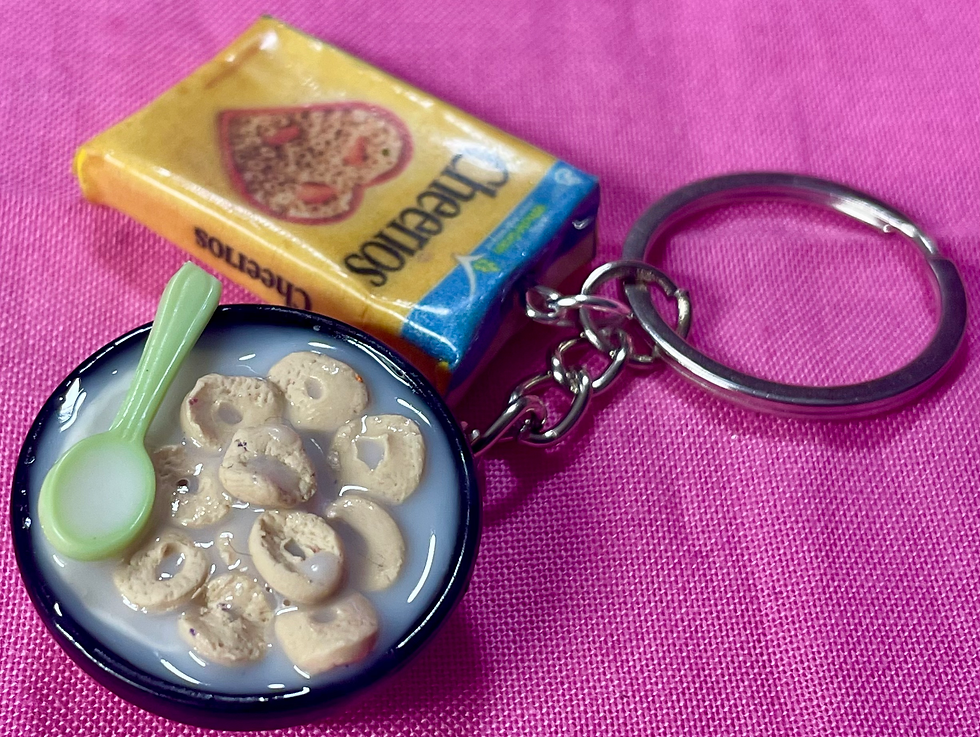 Thumbnail: keychain of a cheerios cereal box and a bowl of cereal with a colorful spoon  in it