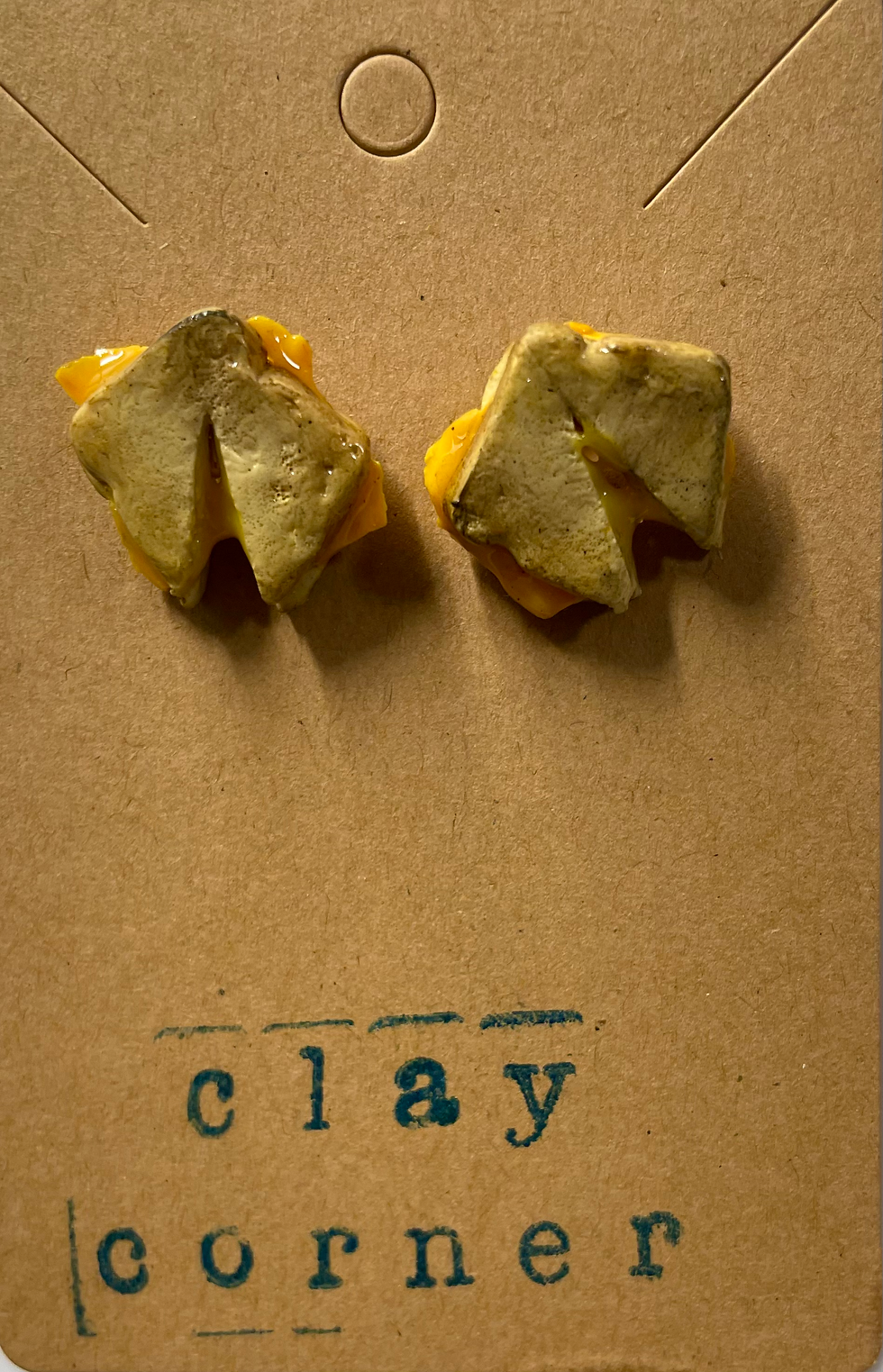 stud food earrings of a grilled cheese sandwich that’s sliced and cheese is melting in the middle