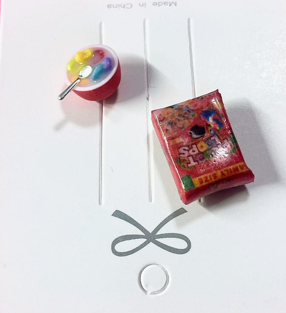 Thumbnail: lapel brooch and pin of a fruit loops cereal box and a bowl of cereal with a tiny spoon  in it