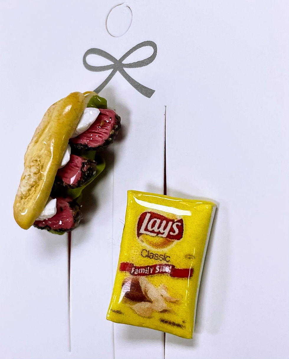 pins of a deli reuben sandwich with roast beef and mozzarella cheese on italian bread hero with a bag of lays potato chips