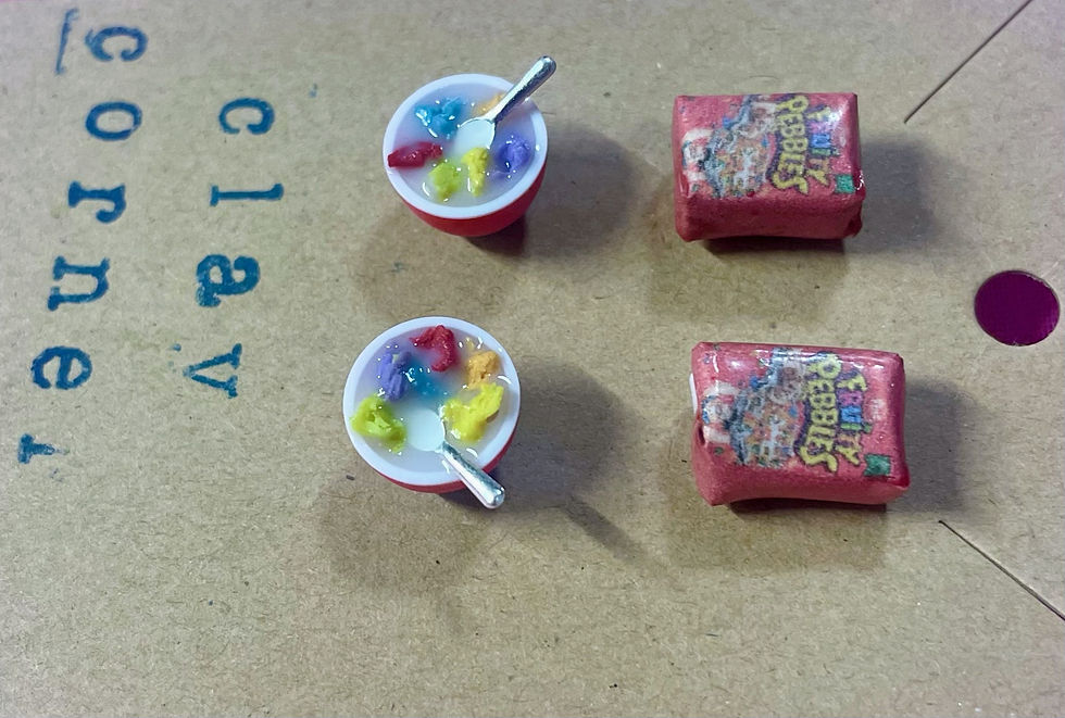 Thumbnail: 2 pairs of stud earrings of Fruity Pebbles cereal boxes and a bowls of cereal with a tiny spoon  in it