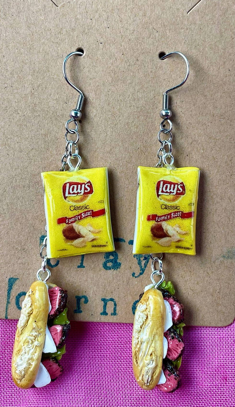 Earrings of deli reuben sandwich with roast beef, mozzarella cheese on italian bread hero with a bag of lays potato chips