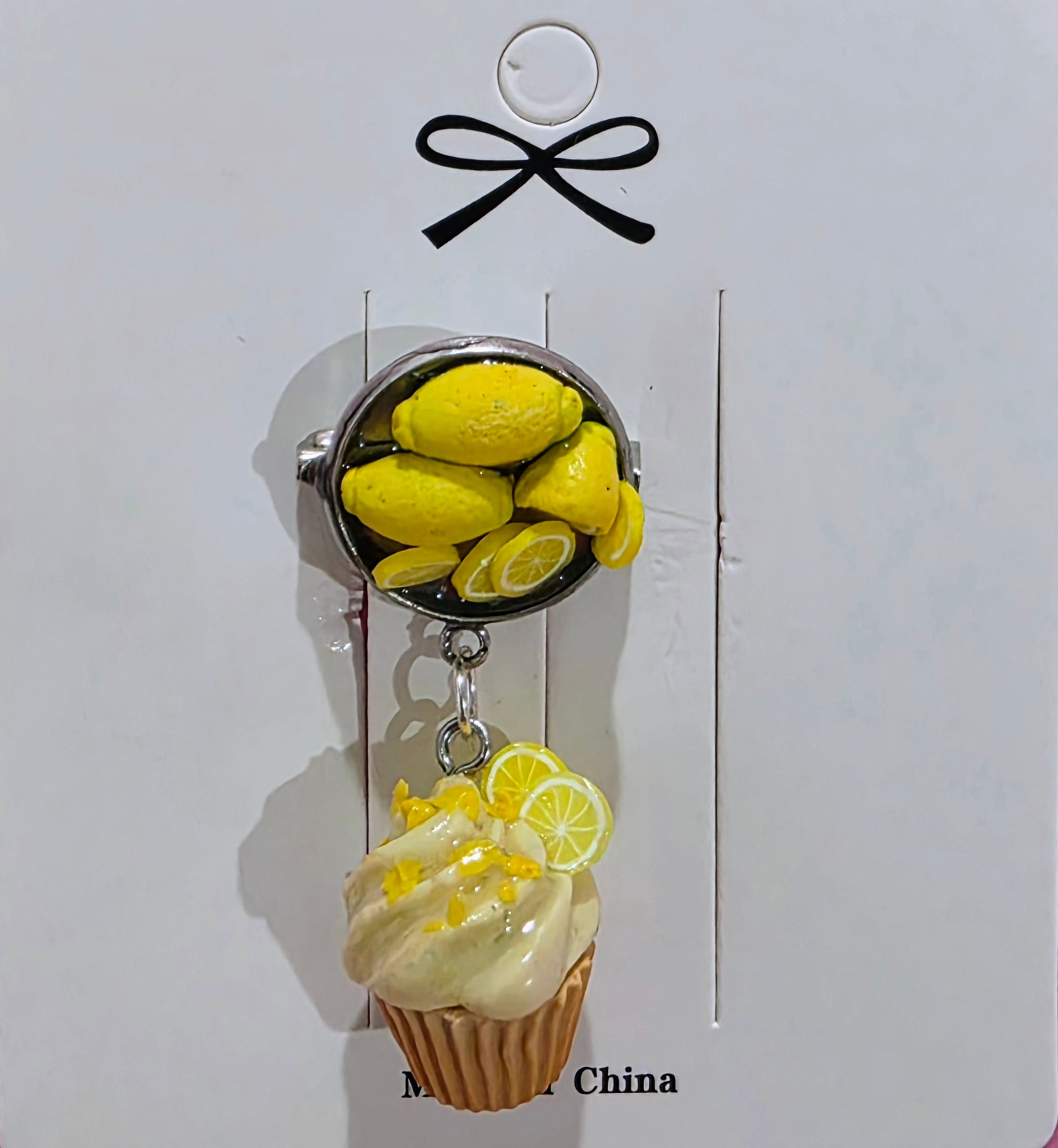 Handmade lemon cupcake pin crafted from polymer clay, featuring a detailed cupcake design.