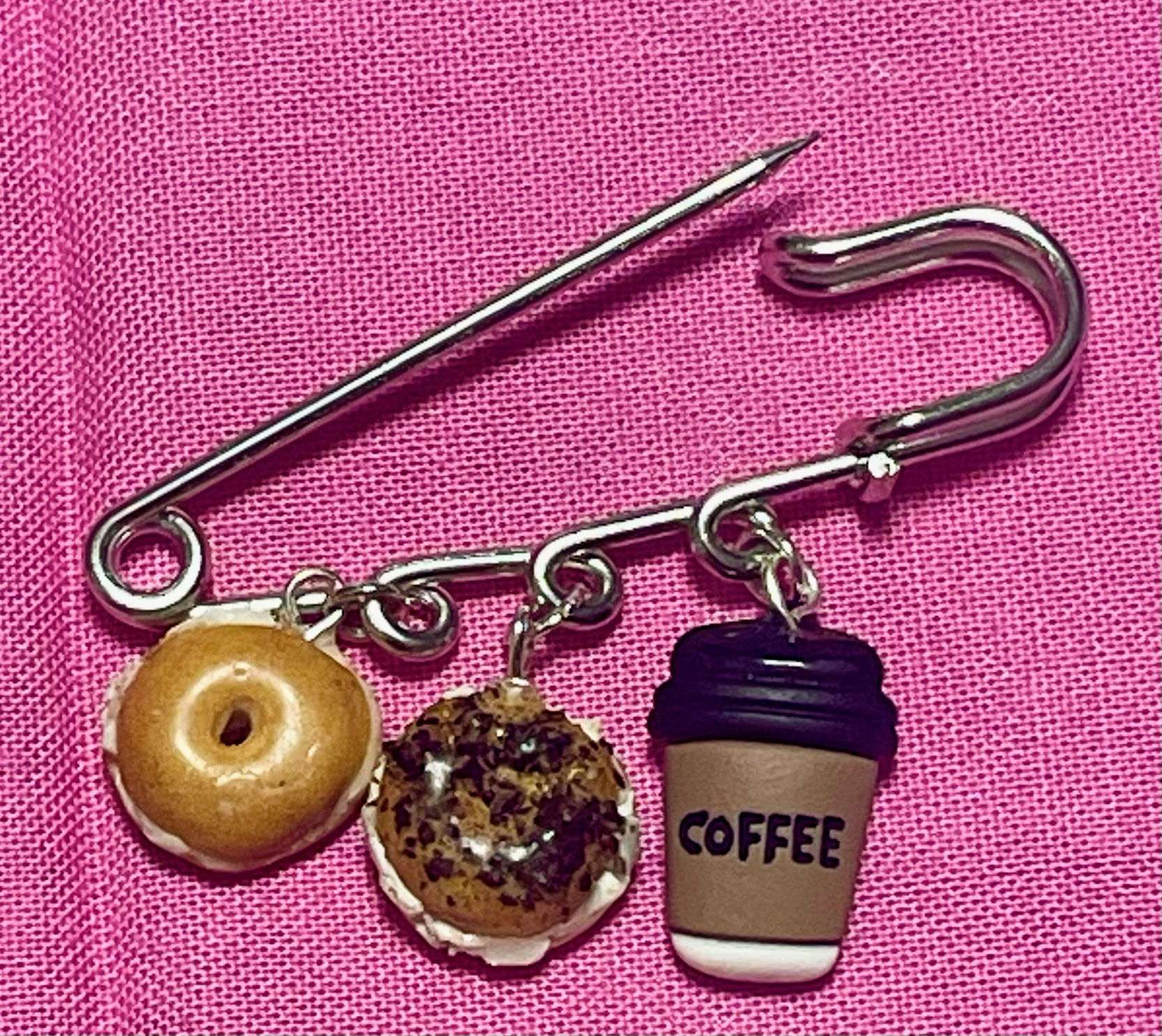 safety pin brooch with 3 charms containing of a plain bagel and a poppyseed bagel and a coffee