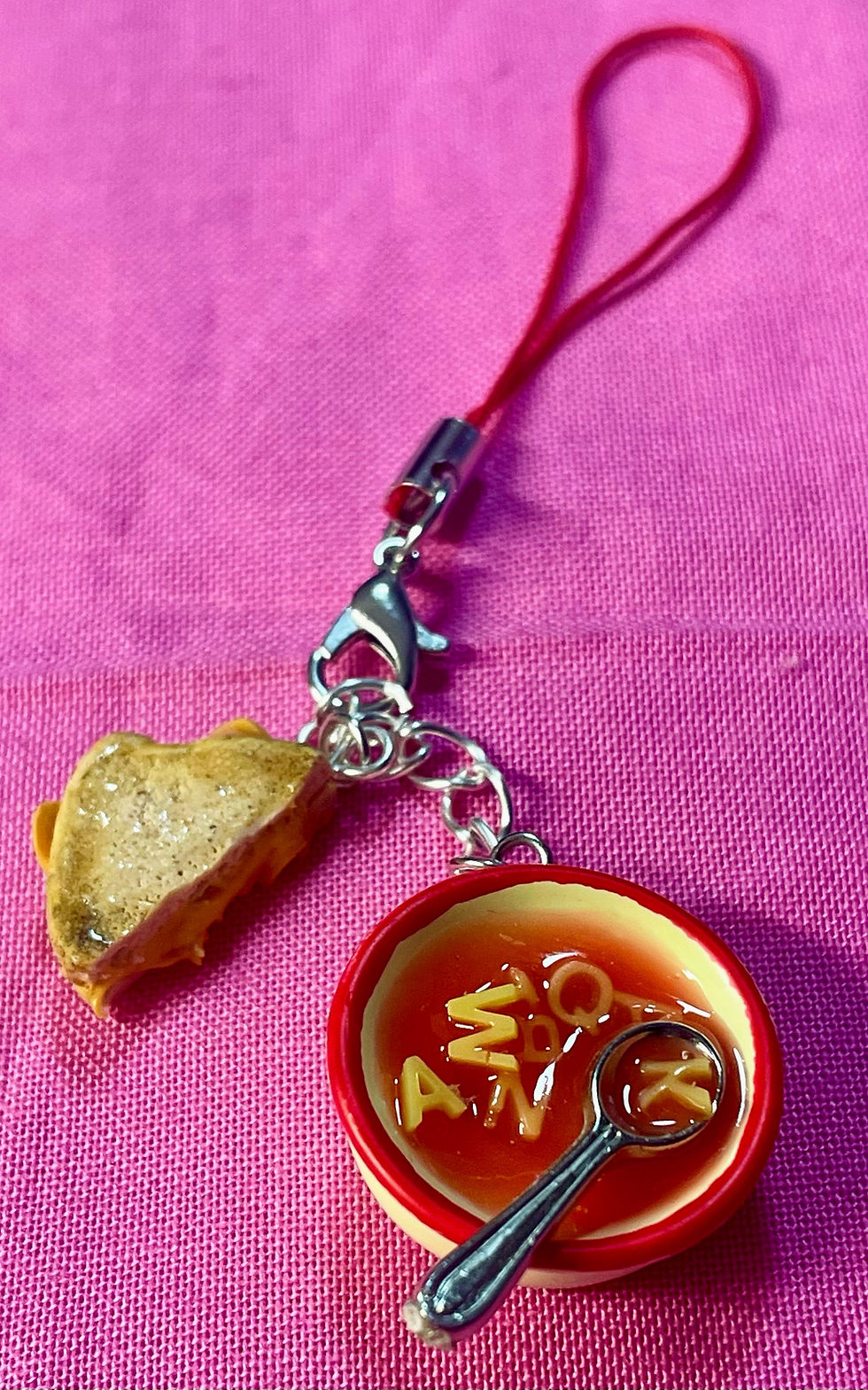 Thumbnail: phone charm of red alphabet soup with tiny spoons with grilled cheese slices and melted cheese