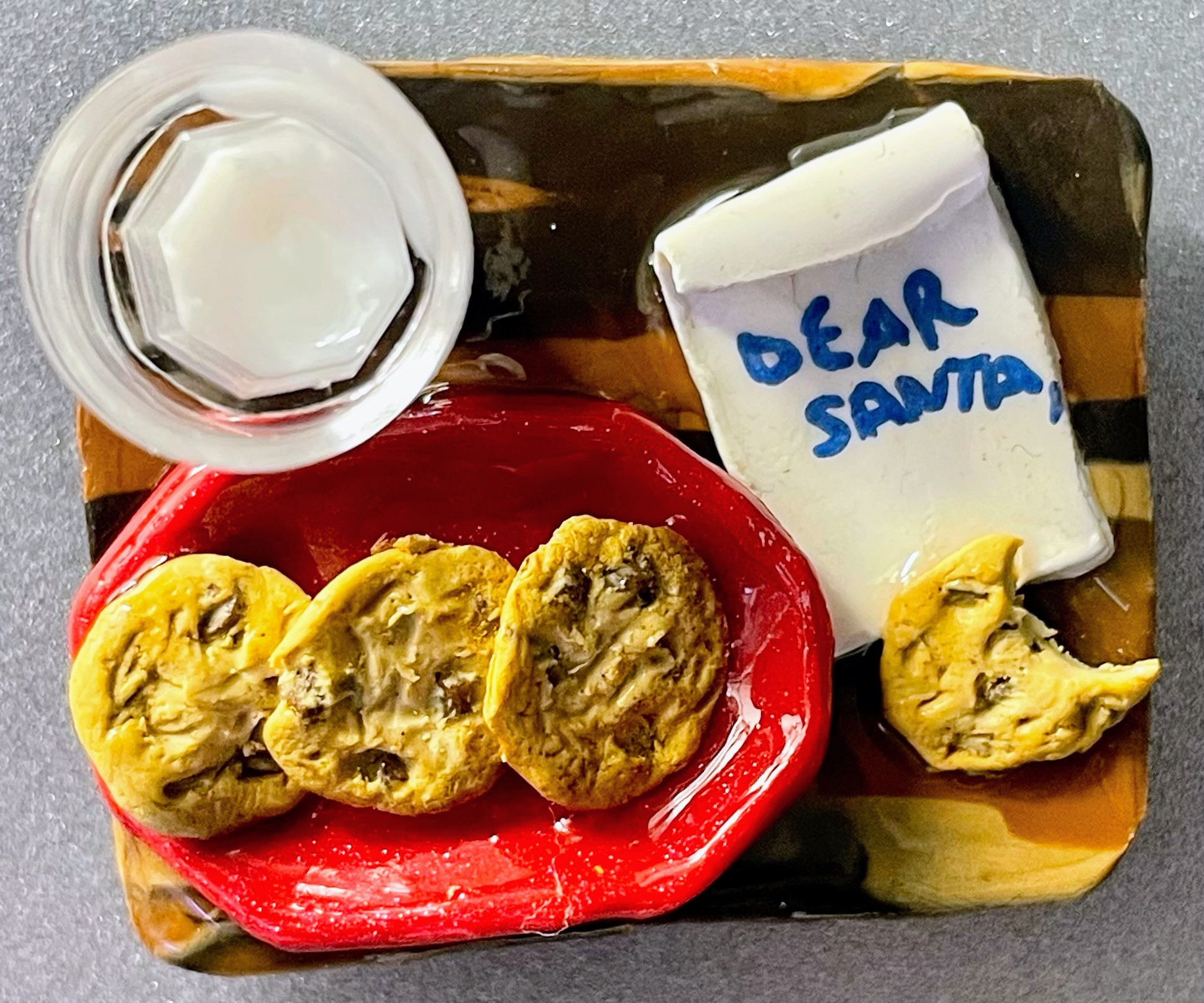 magnet of a wood tray with a glass of milk and a red bowl with chocolate chip cookies and a letter that says dear santa on it