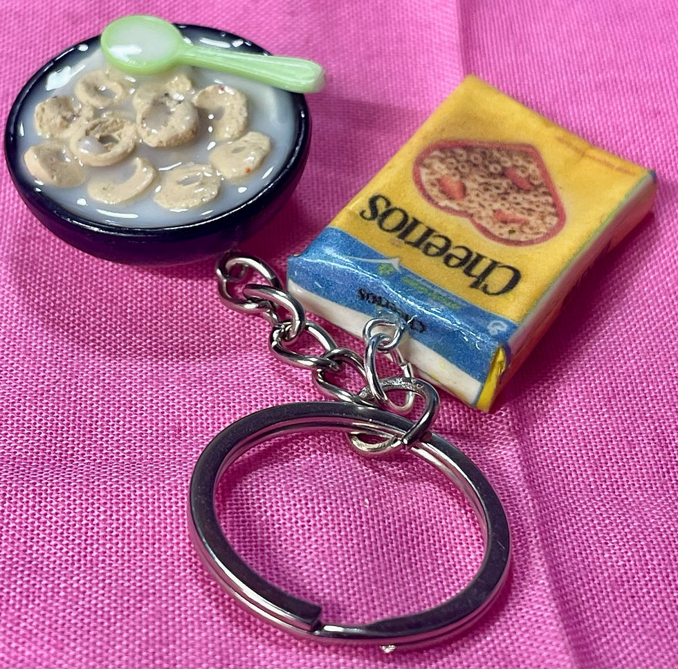 Thumbnail: keychain of a cheerios cereal box and a bowl of cereal with a colorful spoon  in it