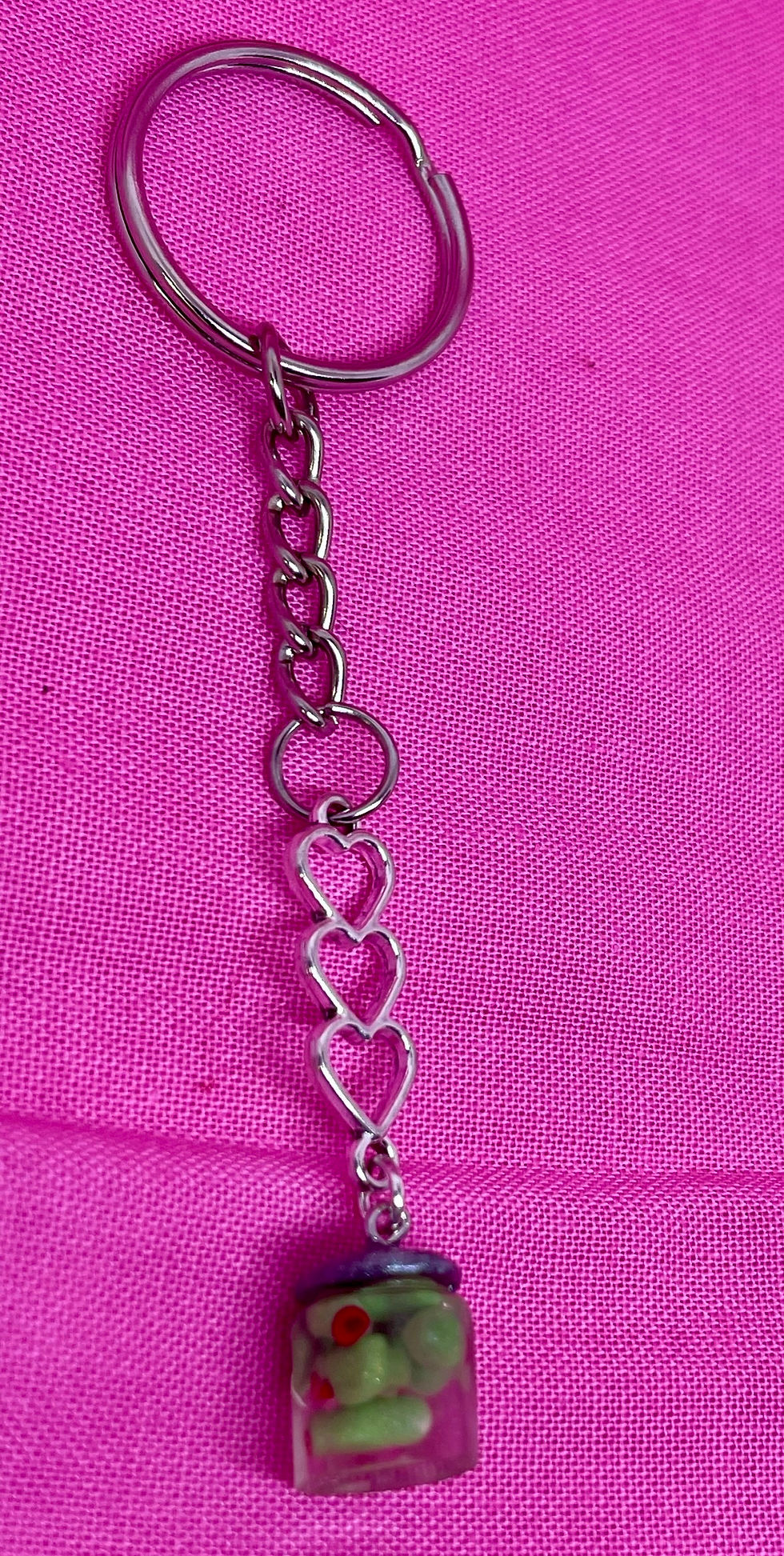 Thumbnail: food keychain of an olive jar with three interlocked hearts