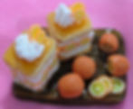 Handmade orange and cream dessert magnet made from polymer clay, featuring a detailed miniature dessert design.