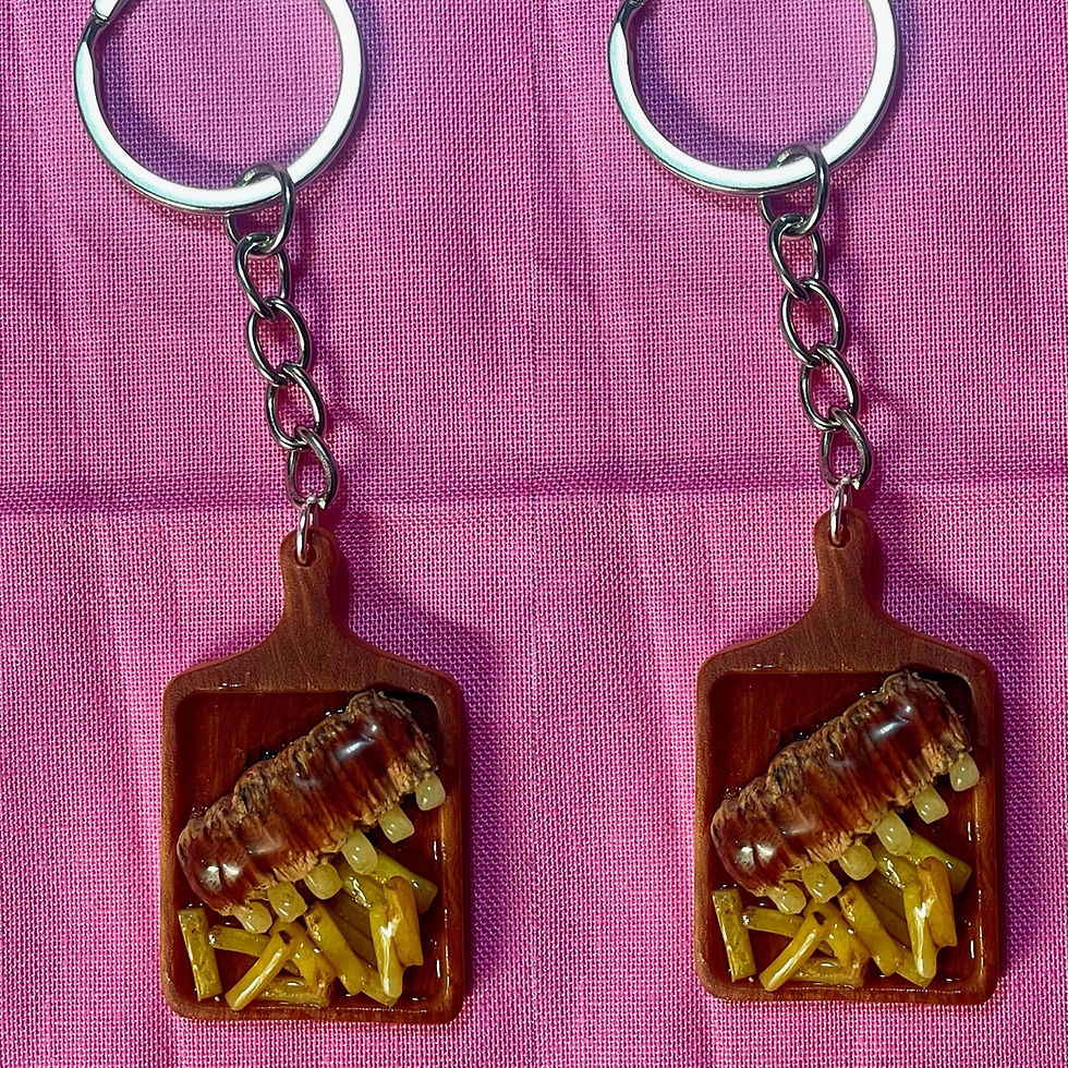keychain of bbq ribs and french fries on a rectangle wooden cutting board