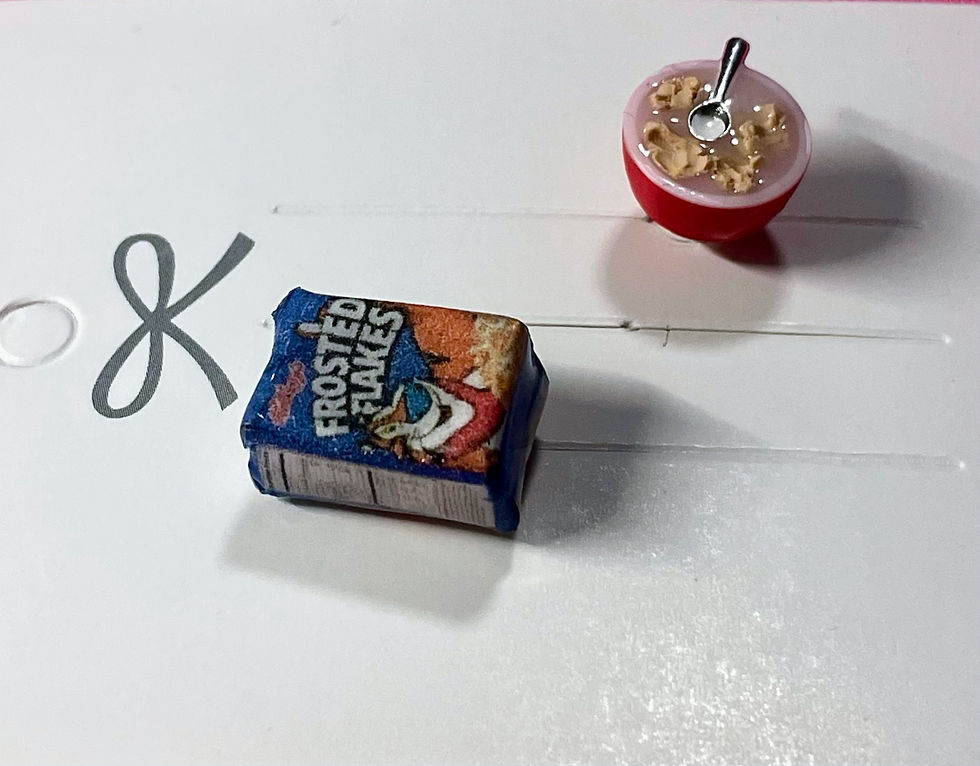 Thumbnail: lapel brooch and pin of a frosted flakes cereal box and a bowl of cereal with a tiny spoon  in it
