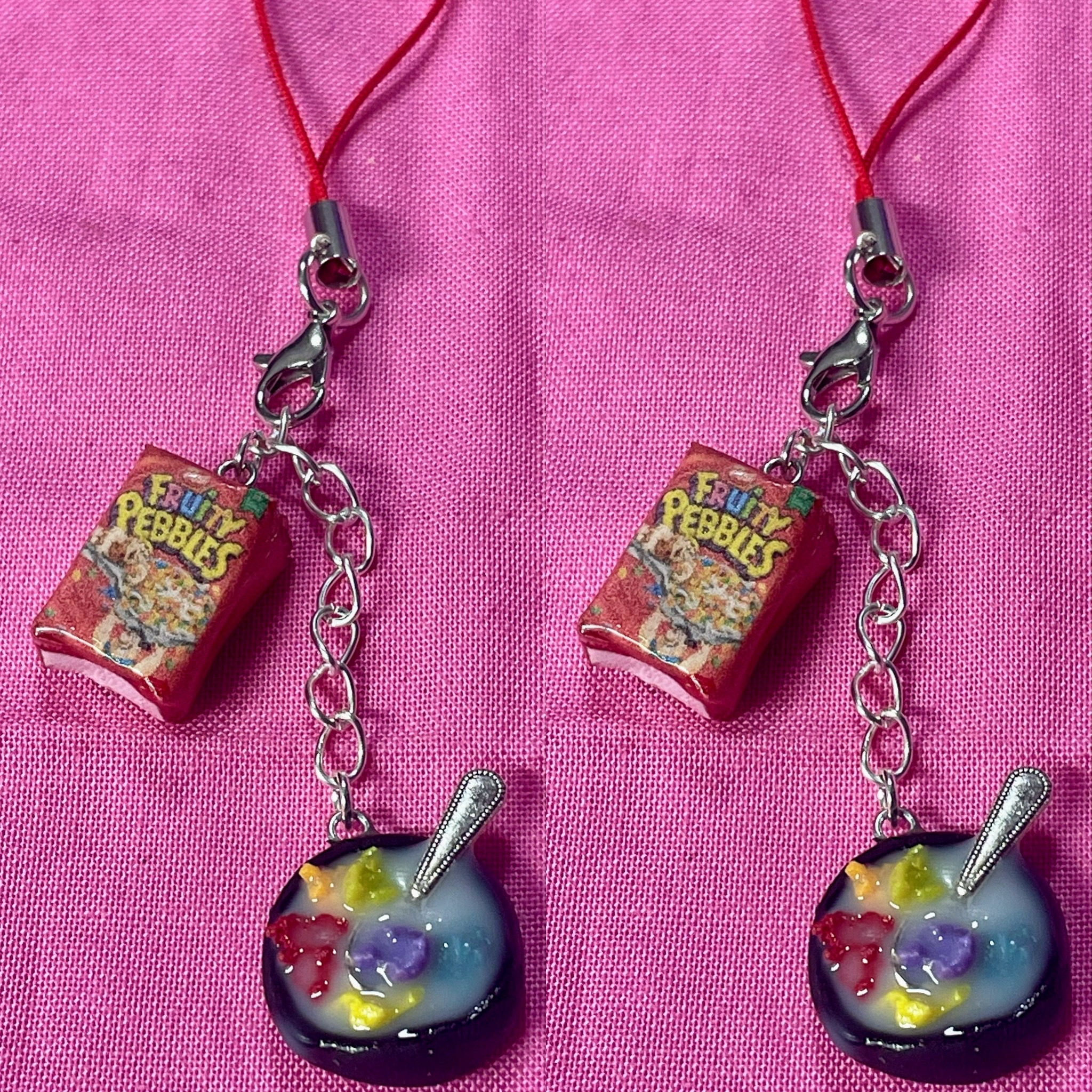 phone charm of a fruity pebbles cereal box and a bowl of cereal with a tiny spoon  in it