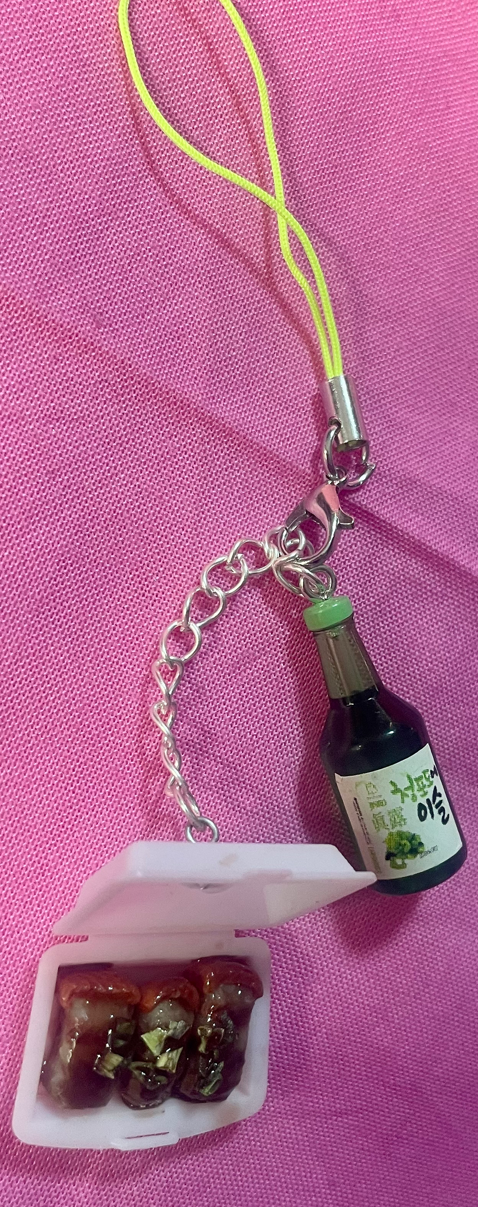 Thumbnail: phone charm of Japanese braised pork belly with scallions in a white takeout container and a sake bottle