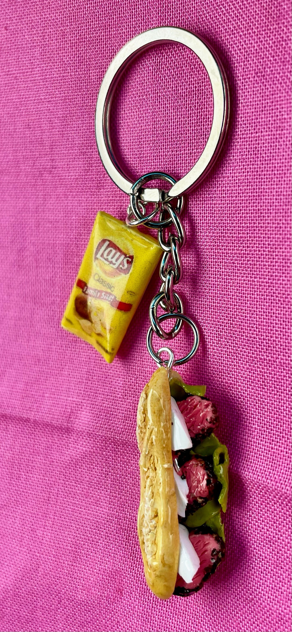 Thumbnail: keychain of a deli reuben sandwich with roast beef, mozzarella cheese on italian bread hero with a bag of lays potato chips