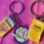 keychain of a cheerios cereal box and a bowl of cereal with a colorful spoon  in it