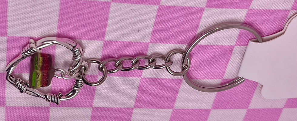 Thumbnail: keychain of a barbed wire heart with an Italian rainbow cookie dangling in the center of the heart