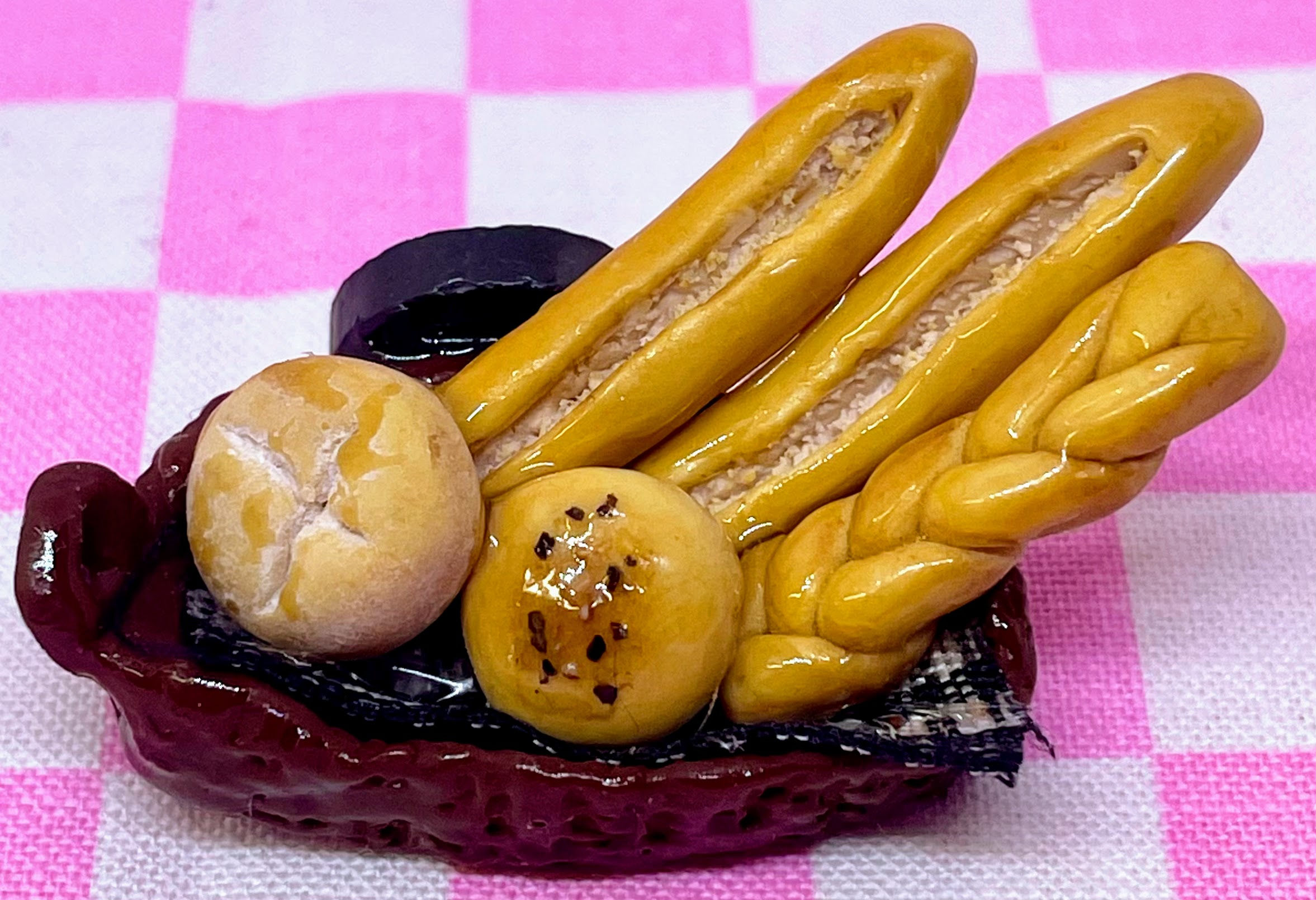 fridge magnet of a woven brown baske with italian bread and braided bread and bread rolls