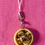 Thumbnail: phone charms of soup dumplings in bamboo steamers with soy sauce and scallions and a dumpling with a bite taken