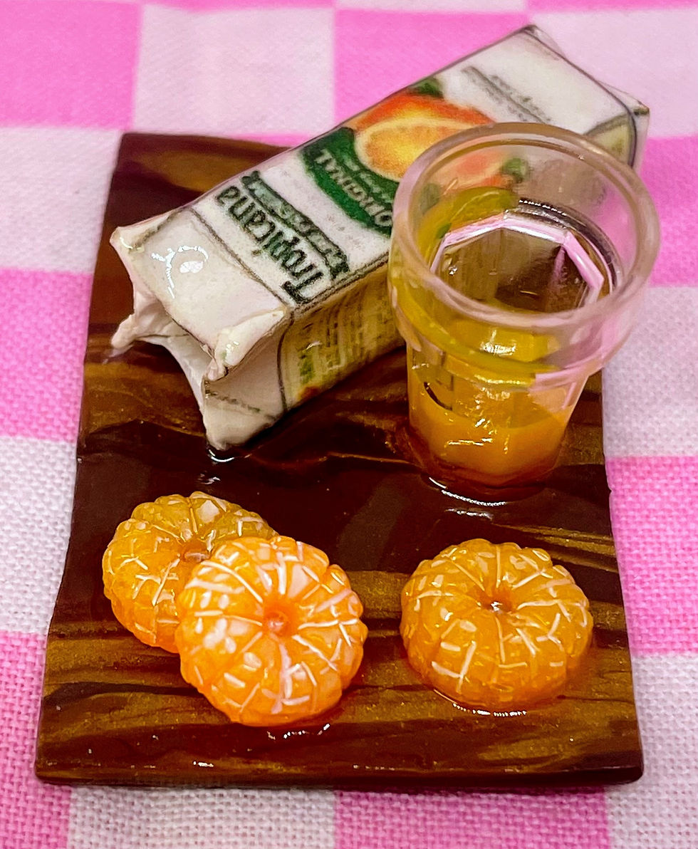 fridge magnet of a Tropicana orange juice box and three orange slices with a glass of orange juice on a wooden cutting board