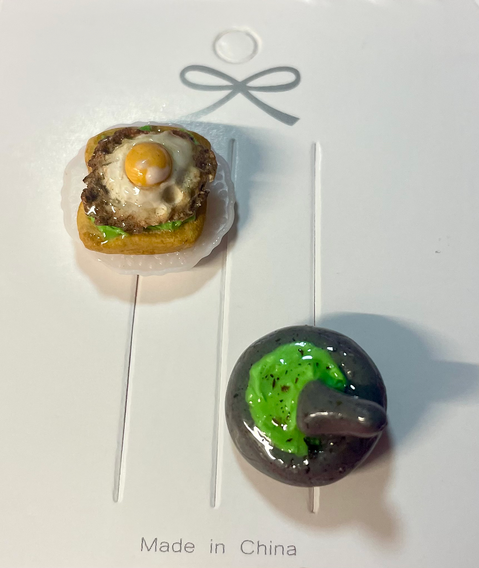 lapel pin of avocado toast with a fried egg on a white dish and avocado in a guacamole grinder