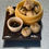 Thumbnail: magnet of soup dumplings in bamboo steamers with soy sauce and scallions and a dumpling with a bite taken on a cutting board