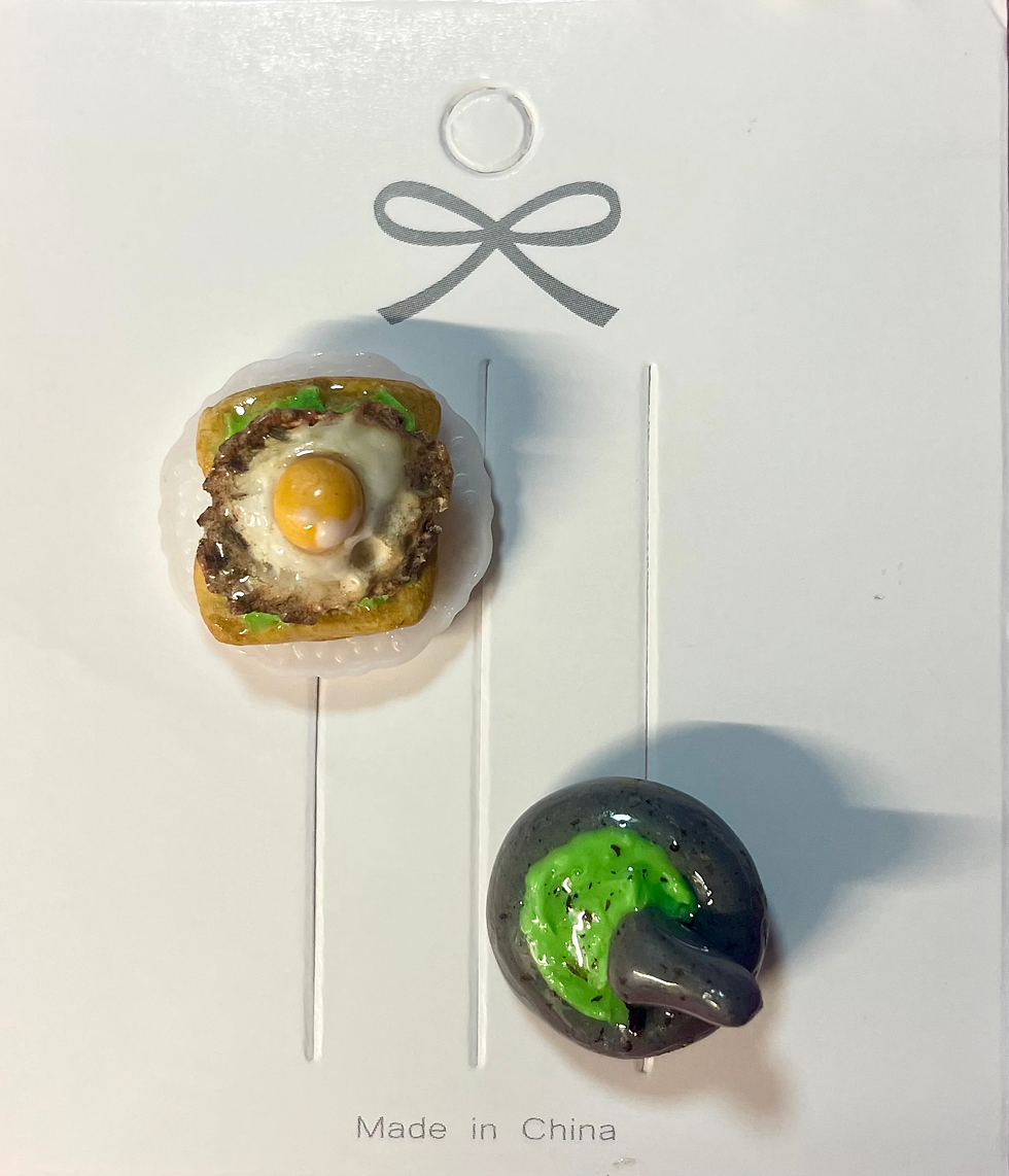 lapel pin of avocado toast with a fried egg on a white dish and avocado in a guacamole grinder
