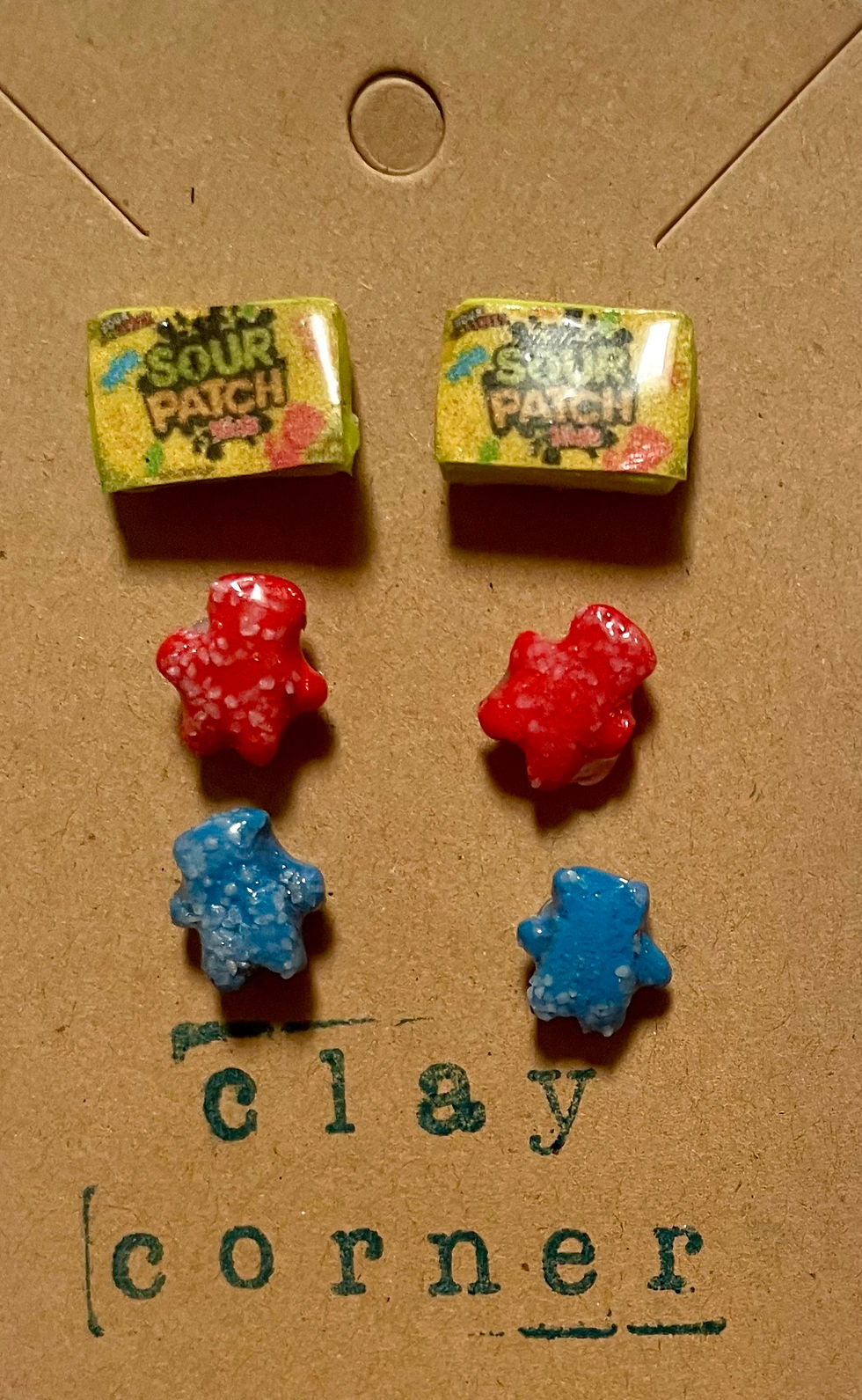 Stud earrings of sour patch kids candy box and a red sour patch kid candy and a blue sour patch kids candy