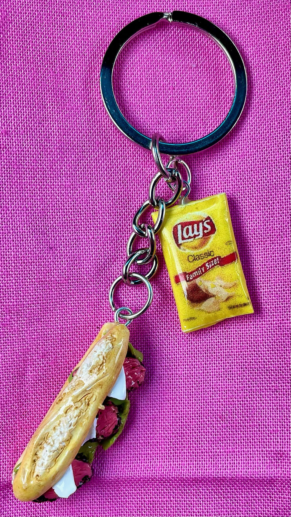 keychain of a deli reuben sandwich with roast beef, mozzarella cheese on italian bread hero with a bag of lays potato chips