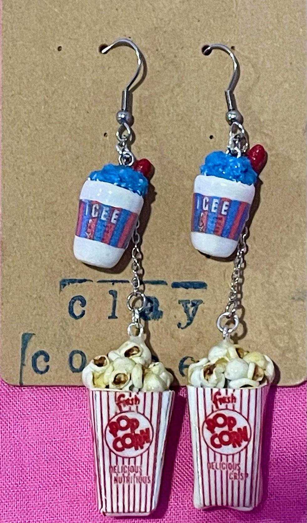dangle earrings of popcorn in a red and white striped popcorn box with a blueberry icee slushee