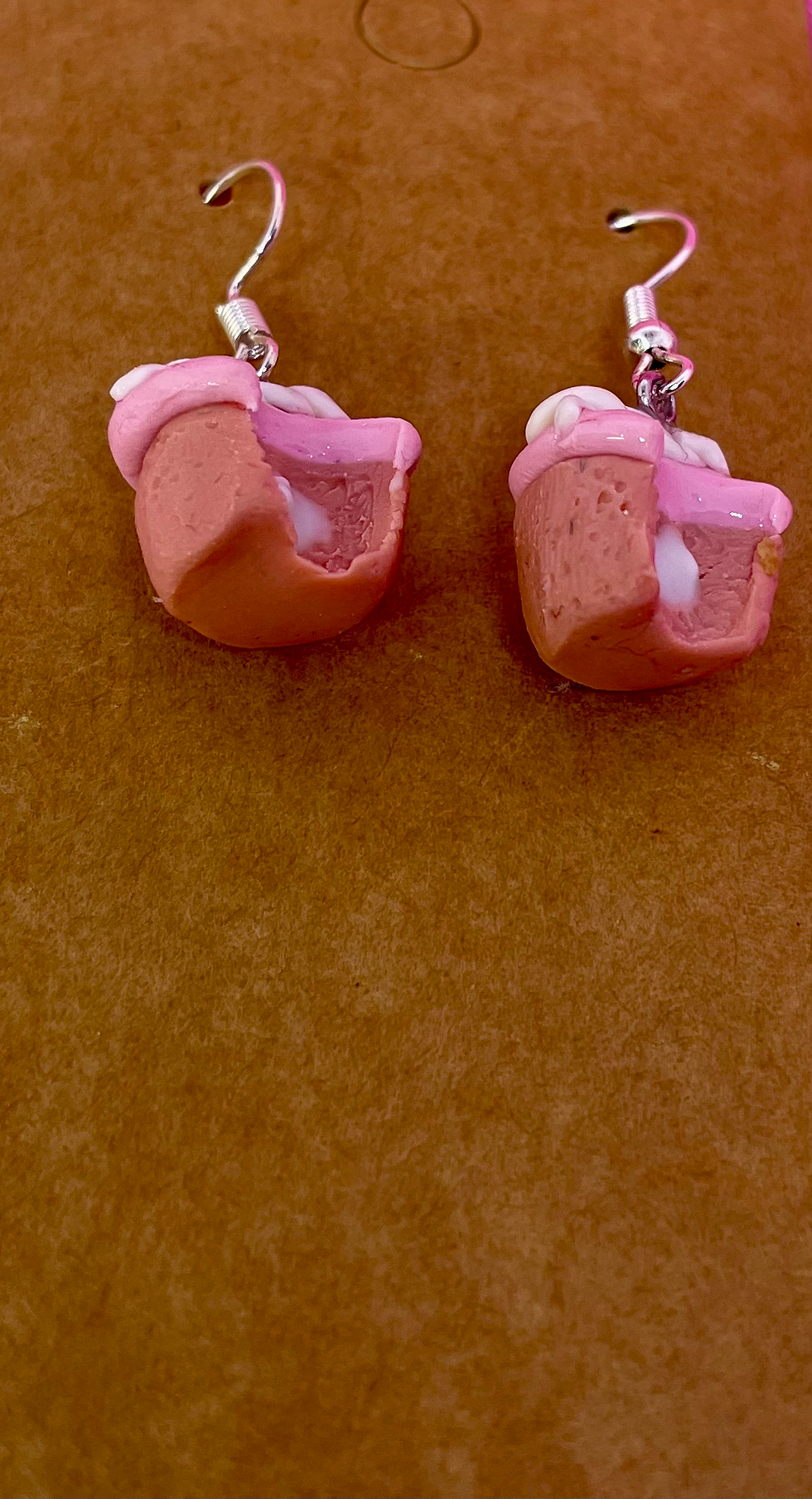 dangle earrings of strawberry flavored hostess cupcakes with a white vanilla swirl