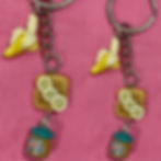 keychain of a slice of bread with peanut butter and bananas and and a whole banana and a peanut butter jar