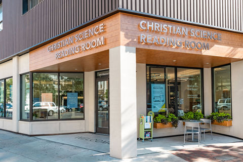 Shop entrance with large wooden sign.