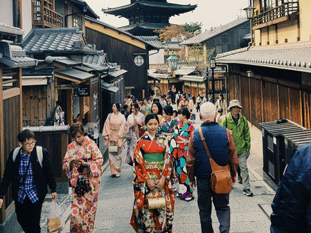 People walking along road leading to a pagoda in Japan. 