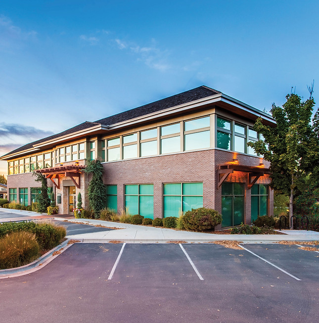A modern two-story office building in Eagle, ID, captured at sunset with a clear blue sky.