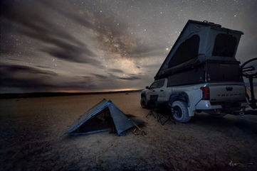 A tent on the desert floor with the Milky Way overhead