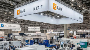 A bustling trade fair hall with booths and people, featuring "K FAIR" signs overhead. Bright lighting and tech displays dominate the scene.