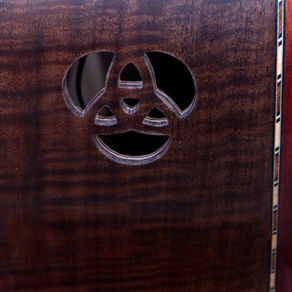 Claro Walnut acoustic guitar with intricate carved Celtic knot side sound port.