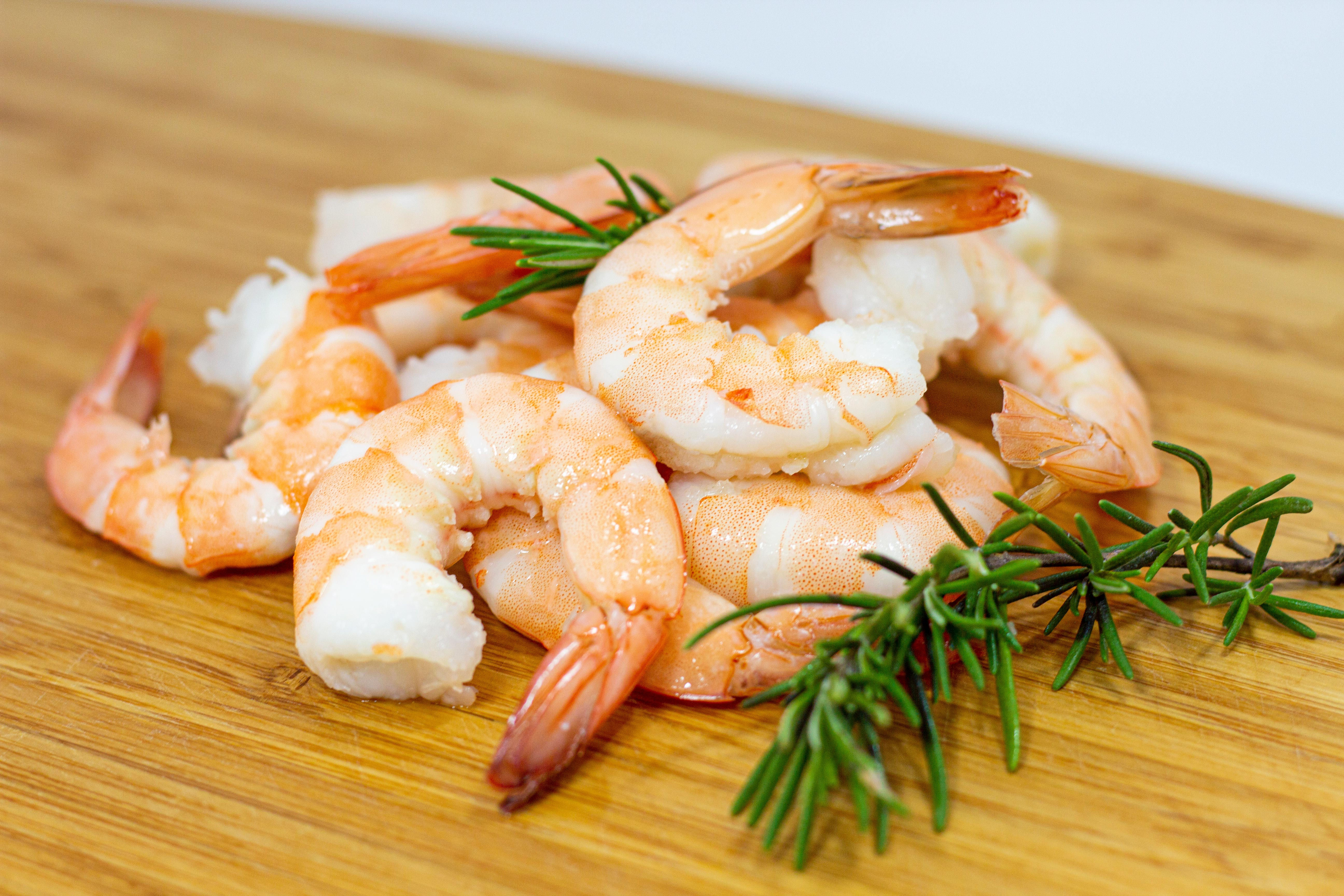 Camarones cocidos y pelados Yavu presentados en una bandeja de madera, listos para consumo y exhibición gastronómica.